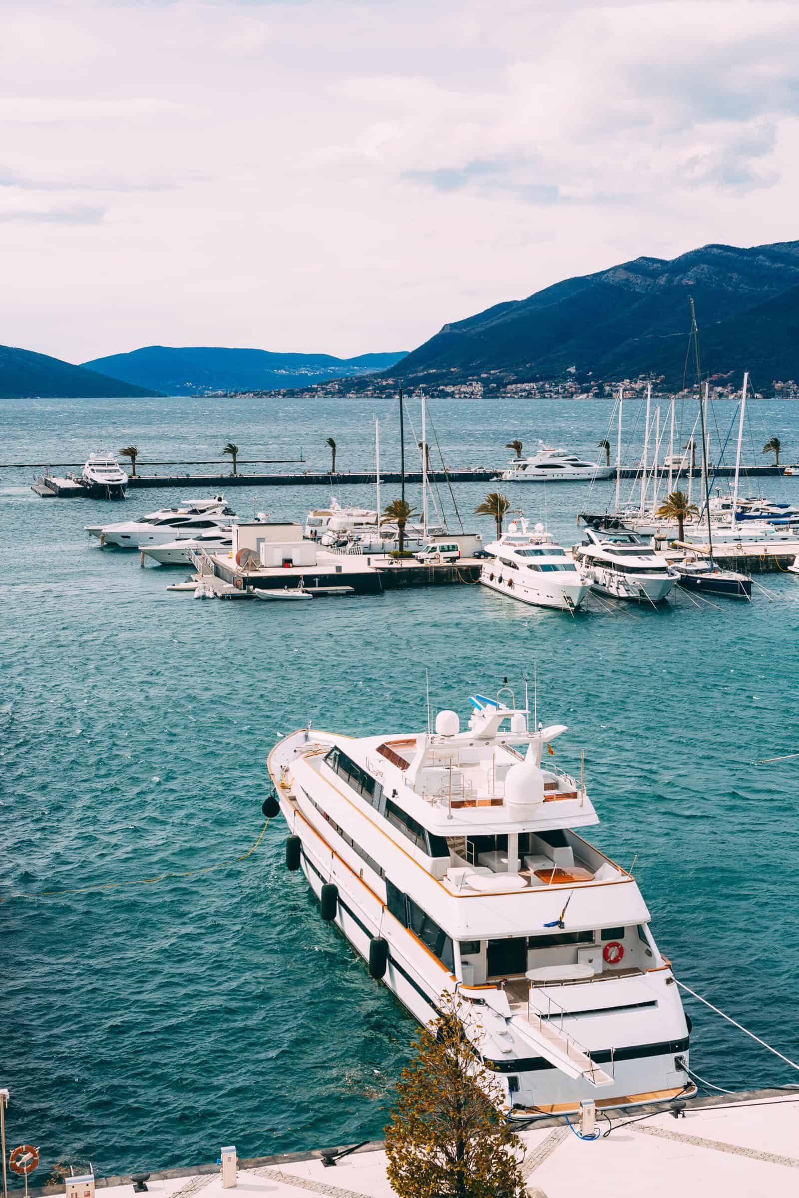 Double-decked white yacht is moored to the pier. Porto, Montenegro