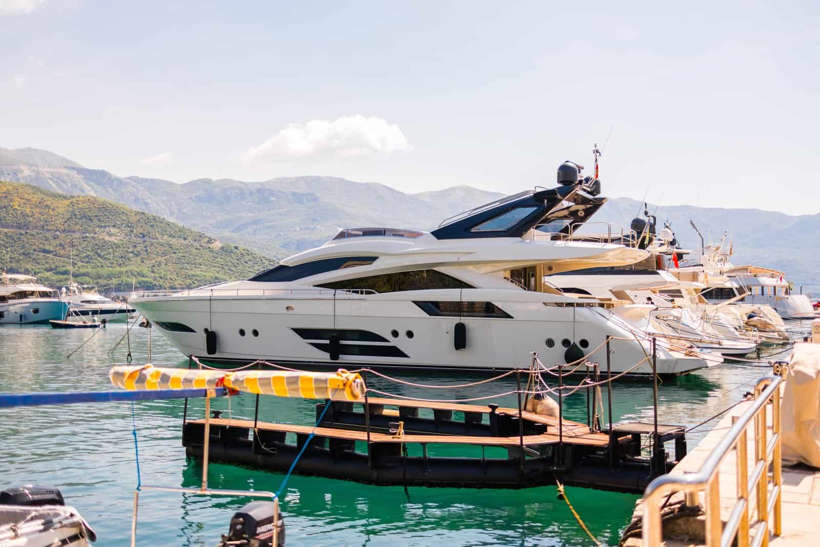Luxury yacht docked in scenic marina on a sunny coastal day. Summer travel, elite leisure, and the lifestyle of Mediterranean seaside tourism.